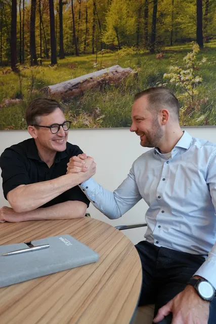 Drehtag bei SYMA: Handschlag am Besprechungstisch